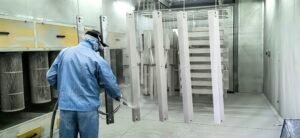 Worker spraying surface coating with spray gun